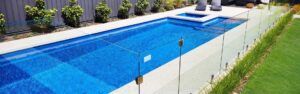 Glass panes and pool coping around a swimming pool.